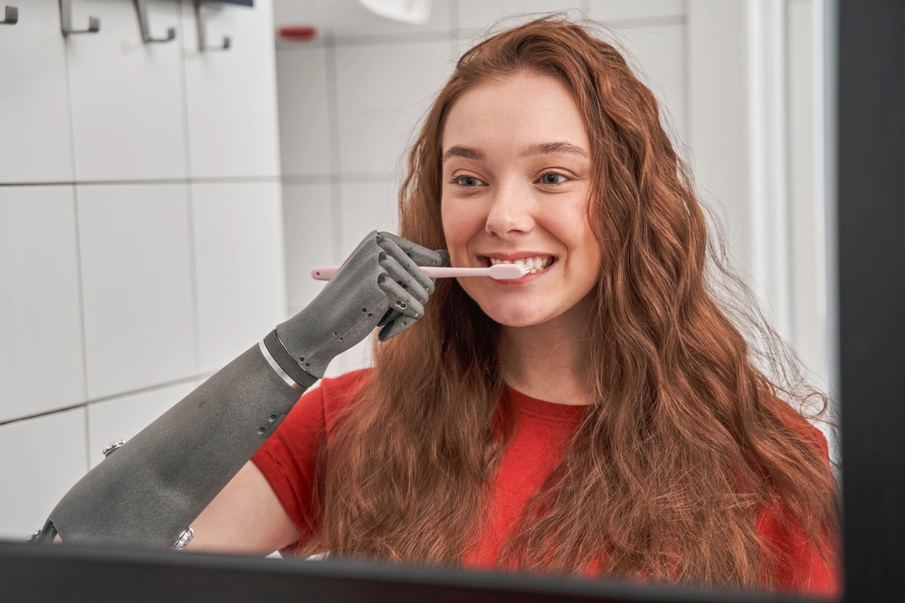 women with a disabled prosthetic hand brushing her teeth