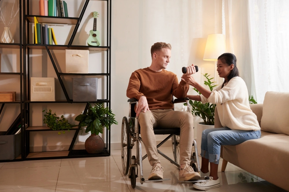 carer helping a men do exercise and lift a dumbbell
