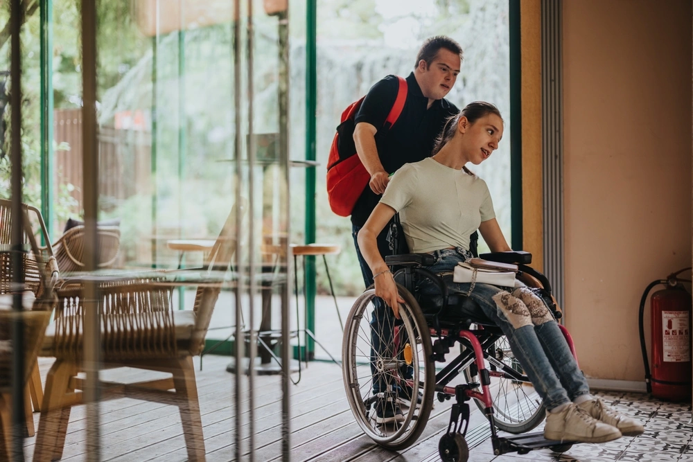 down syndrome brother helping sister on wheel chair