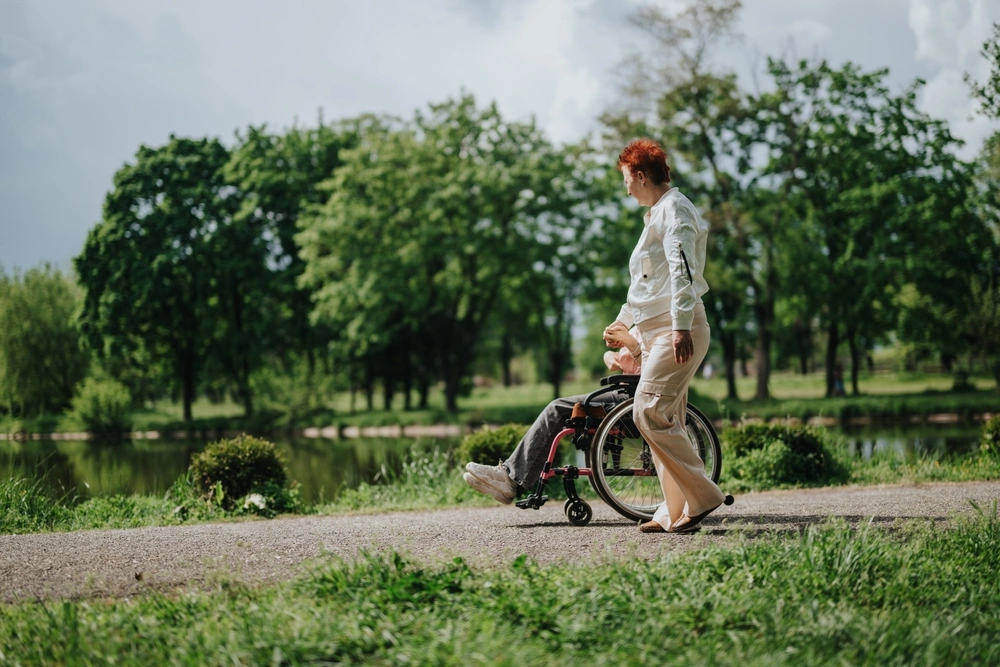 carer with a disabled person in a park